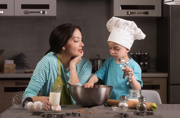 Famille heureuse dans la cuisine Mère et fils en toque