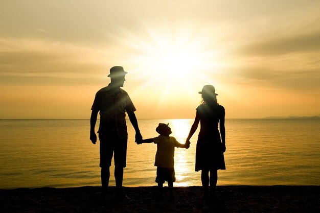 Une famille heureuse dans la nature au bord de la mer sur une silhouette de voyage