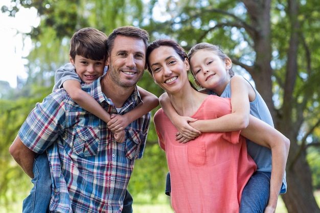 Famille heureuse dans le parc ensemble