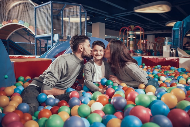 Une famille heureuse dans la piscine avec des balles repose ensemble.