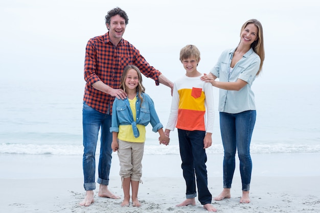 Famille heureuse, debout, bord mer, ciel