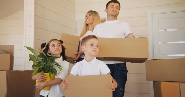 Famille heureuse avec deux enfants à la nouvelle maison. Mère père et enfant dans une nouvelle maison