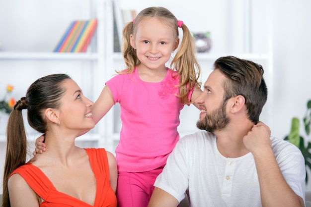 Famille heureuse avec un enfant assis sur le canapé à la maison.