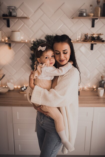 Famille heureuse avec enfant célébrant le Nouvel An et Noël à l'arbre de Noël décoré et au garlan