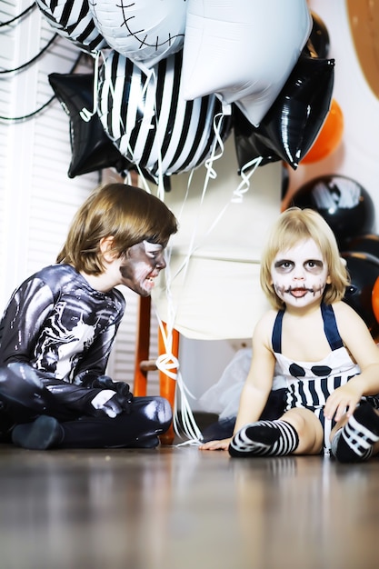 famille heureuse avec des enfants en costumes et maquillage à l'occasion de la célébration d'Halloween