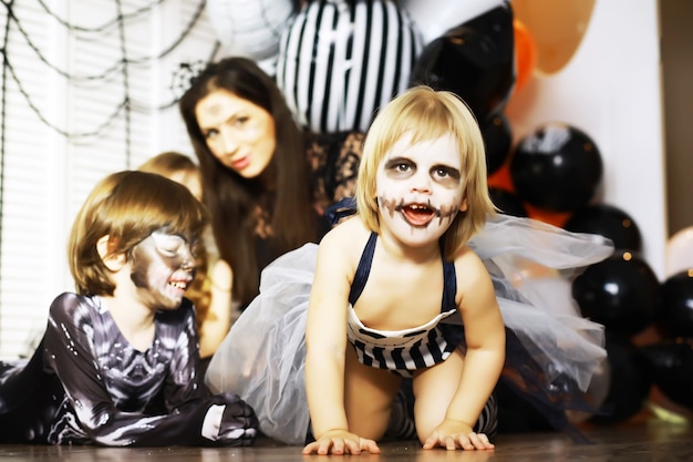 famille heureuse avec des enfants en costumes et maquillage à l'occasion de la célébration d'Halloween