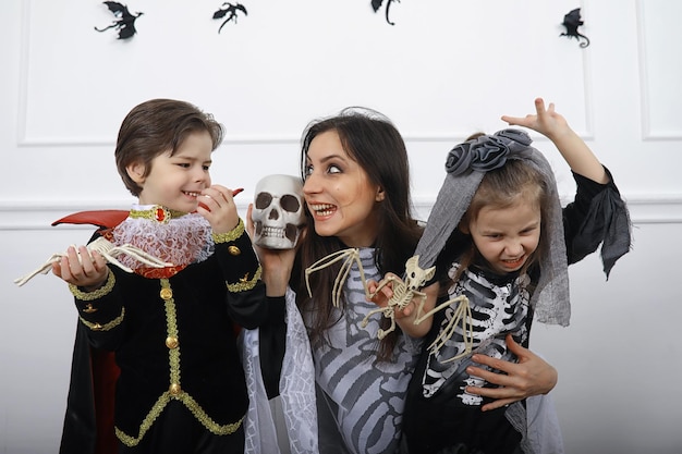 Famille heureuse avec des enfants en costumes de sorcière et de vampire dans une maison en vacances Halloween