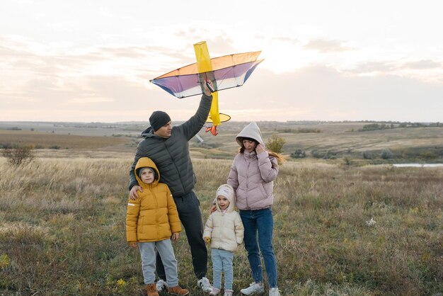 Une famille heureuse avec des enfants fait voler un cerf-volant et passe du temps ensemble à l'extérieur dans une réserve naturelle Bonne enfance et vacances en famille Liberté et espace