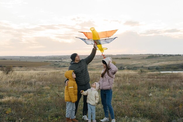 Une famille heureuse avec des enfants fait voler un cerf-volant et passe du temps ensemble à l'extérieur dans une réserve naturelle Bonne enfance et vacances en famille Liberté et espace