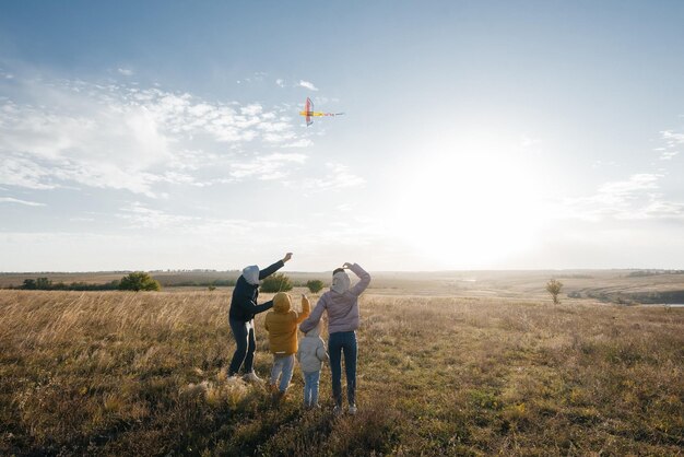 Une famille heureuse avec des enfants fait voler un cerf-volant et passe du temps ensemble à l'extérieur dans une réserve naturelle Bonne enfance et vacances en famille Liberté et espace
