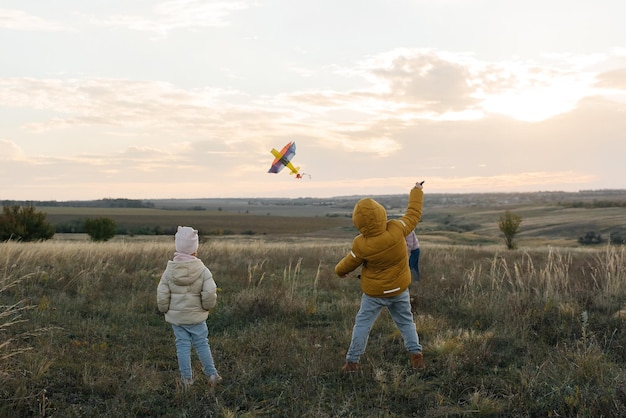 Une famille heureuse avec des enfants fait voler un cerf-volant et passe du temps ensemble à l'extérieur dans une réserve naturelle Bonne enfance et vacances en famille Liberté et espace