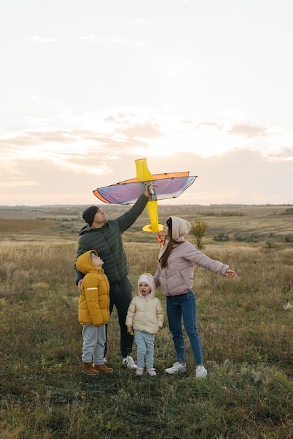 Une famille heureuse avec des enfants fait voler un cerf-volant et passe du temps ensemble à l'extérieur dans une réserve naturelle Bonne enfance et vacances en famille Liberté et espace