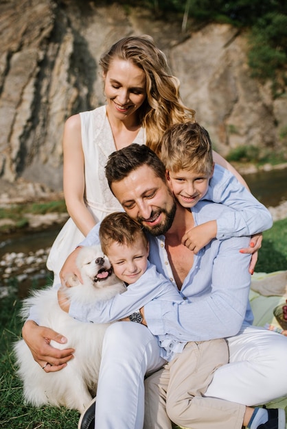 Famille heureuse avec enfants en pique-nique dans le parc national au bord de la rivière