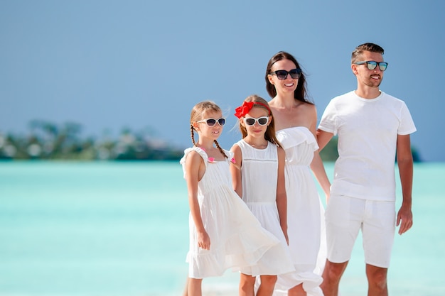 Famille heureuse avec des enfants sur la plage ensemble