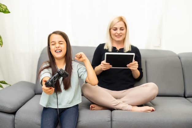 famille heureuse ensemble. mère et sa petite fille jouant à des jeux vidéo. famille se détendre.