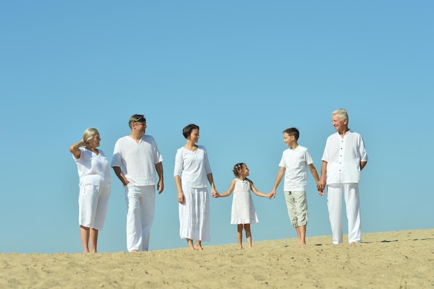 Famille heureuse ensemble sur la plage de sable