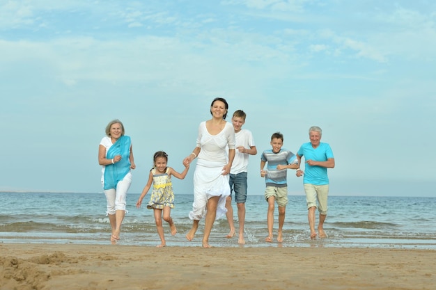 Famille heureuse ensemble sur la plage de sable