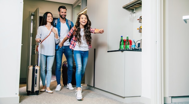 Une famille heureuse entrant dans la chambre d'hôtel