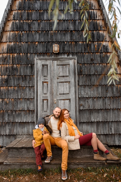 Une Famille Heureuse Est Assise Sur Les Marches Devant L'entrée De La Maison.