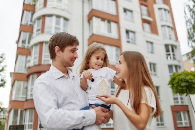 Famille heureuse en face du nouvel immeuble