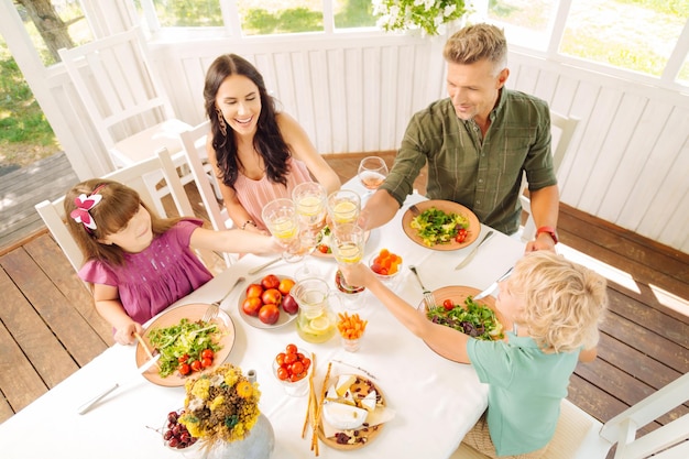 Famille heureuse faisant claquer leurs verres avec de la limonade