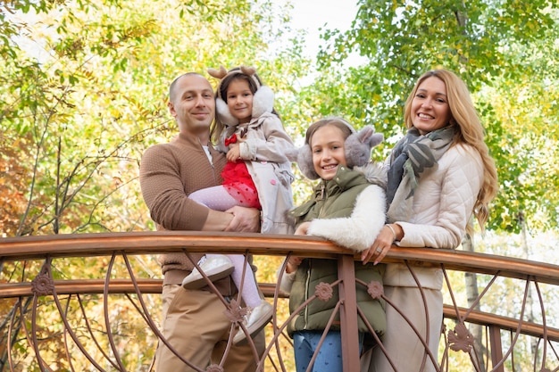 Famille heureuse, femme, mari, filles, marcher avec des enfants, jouer dans le parc en automne, s'amuser en forêt, se détendre en plein air. Fun, enfance, détente, concept de saison