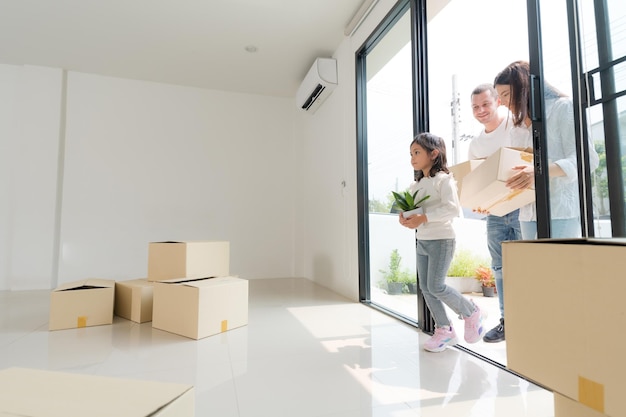 Famille heureuse avec une fille emménageant dans une nouvelle maison