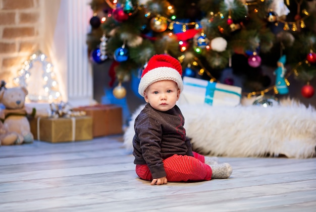 Famille heureuse à l'intérieur d'une maison sur fond d'arbre de Noël avec des cadeaux