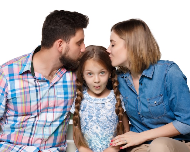 Une famille heureuse isolée sur fond blanc. Parents embrassant bébé