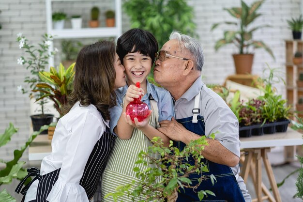 Famille heureuse jardinant ensemble dans le jardin grand-père petit-fils et femme prenant soin de la nature