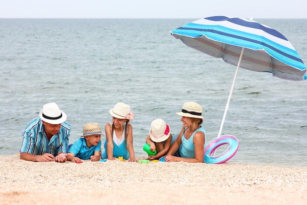 Une famille heureuse jouant au bord de la mer sur le fond de sable