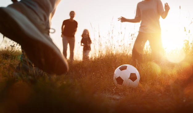 Une famille heureuse jouant au football.