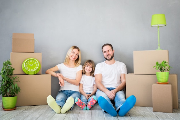 Famille heureuse jouant dans la nouvelle maison Père mère et enfant s'amusant ensemble Jour du déménagement