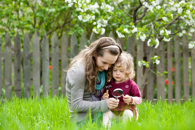 Famille heureuse jouant dehors dans le jardin de ressort sur le fond fleuri