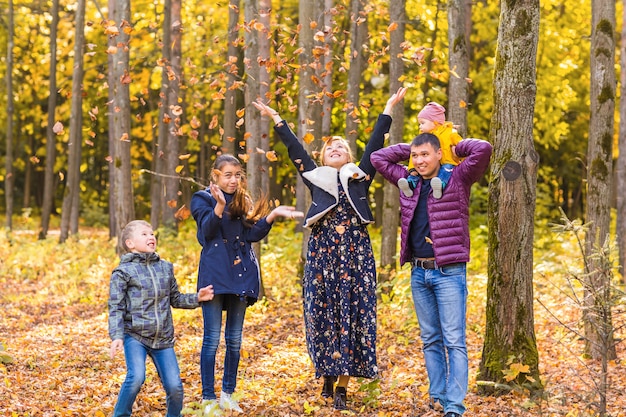 famille heureuse jouant avec les feuilles d'automne dans le parc