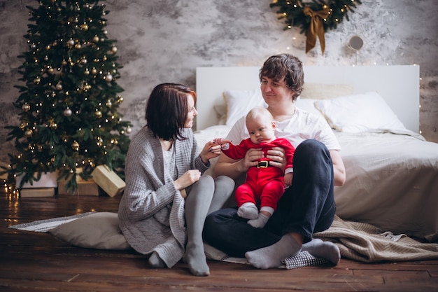 Famille heureuse avec leur bébé à Noël