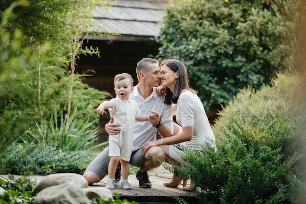 Photo famille heureuse avec leur fils marchant dans le parc au coucher du soleil. bonheur. l'amour