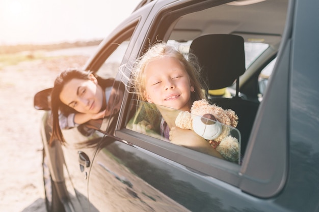 Famille heureuse lors d'un road trip dans leur voiture. Papa, maman et sa fille voyagent par la mer, l'océan ou la rivière. Balade d'été en automobile