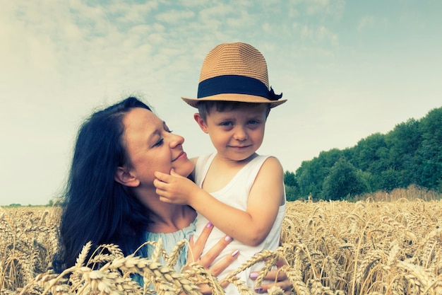 Famille heureuse Maman et fils rient et parlent sur le champ de blé Vue de face