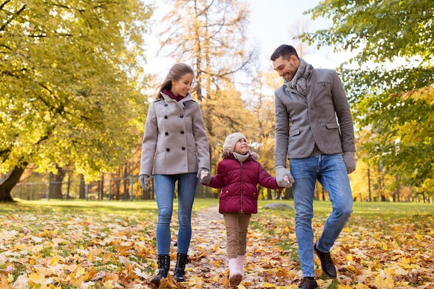 famille heureuse marchant au parc d'automne