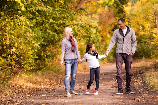 Photo famille heureuse marchant dans le parc en automne