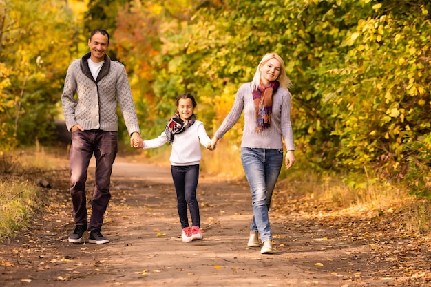 Photo famille heureuse marchant dans le parc en automne