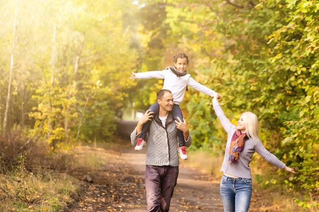 famille heureuse marchant dans le parc d'automne