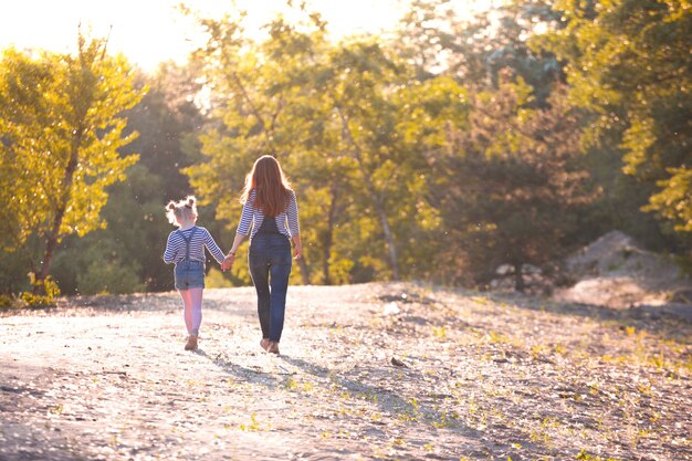 Famille heureuse - Mère et fille en promenade au coucher du soleil