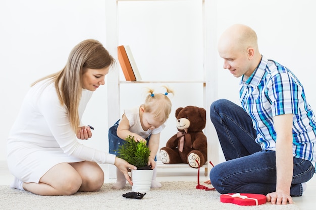 Famille heureuse, mère, père et leur bébé jouant ensemble dans le salon à la maison.