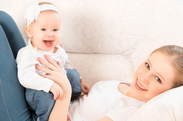 Famille heureuse mère et petite fille à la maison sur le canapé à la maison