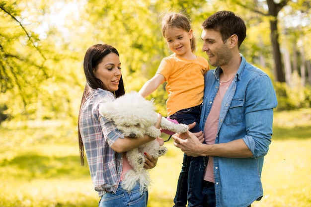 Famille heureuse avec mignon chien bichon dans le parc