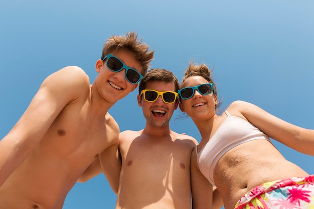 Famille heureuse Papa et deux adolescents dans des lunettes de soleil colorées rient grand angle