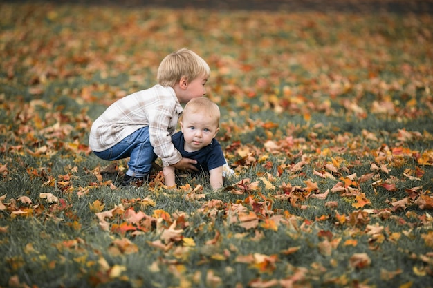 Famille heureuse en pique-nique Petit bébé rampant sur l'herbe verte Été dans le parc Frères et sœurs enfants jouant dans le parc vert Famille amusement et joie dans l'aire de jeux Fils actif rampant pieds nus dans le champ