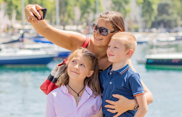 famille heureuse prenant selfie. Maman et ses enfants prennent une photo ensemble